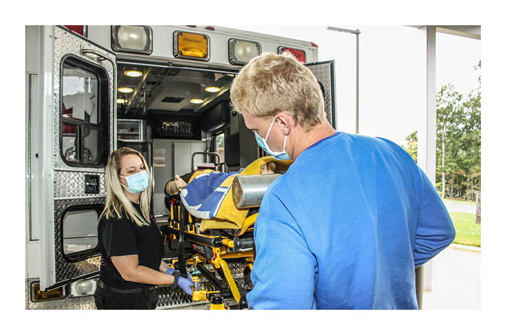 Two EMT Student Loading Stretcher Into Ambulance
