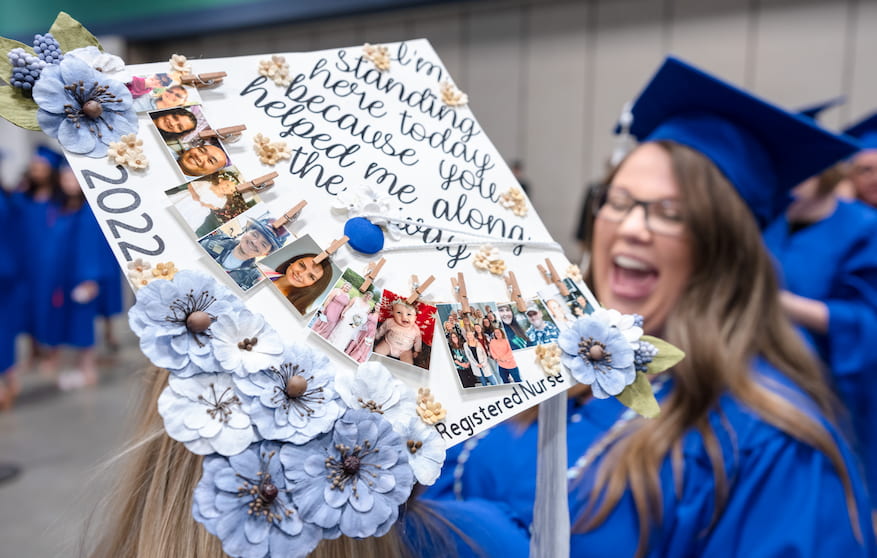 Decorated mortar board with woman laughing in the background.