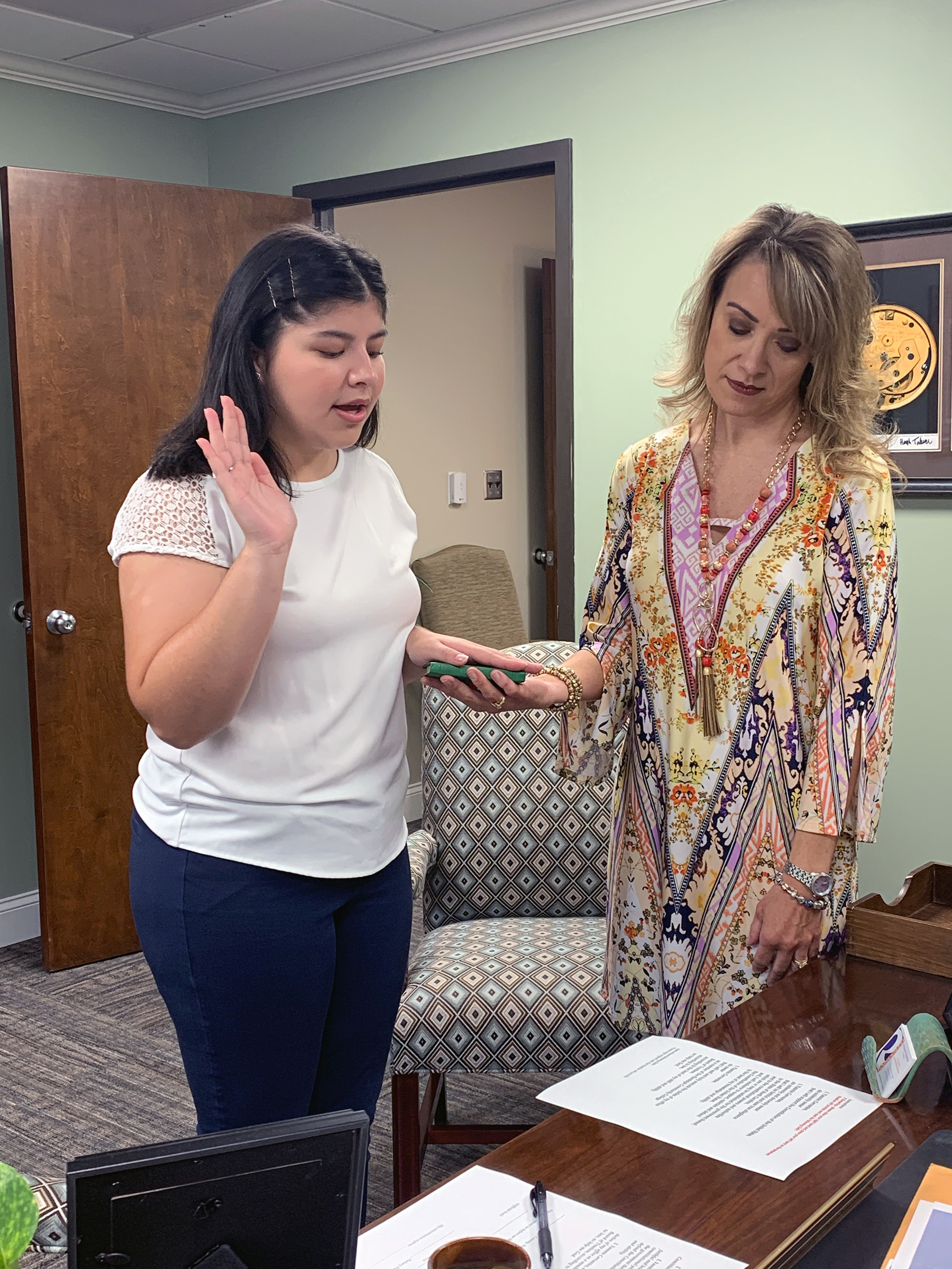 Heather Clouston (right), Executive Assistant to the President and Board of Trustees, administers the oath of office to new Board student trustee and Student Government Association President Yasmin Cervantes July 15.