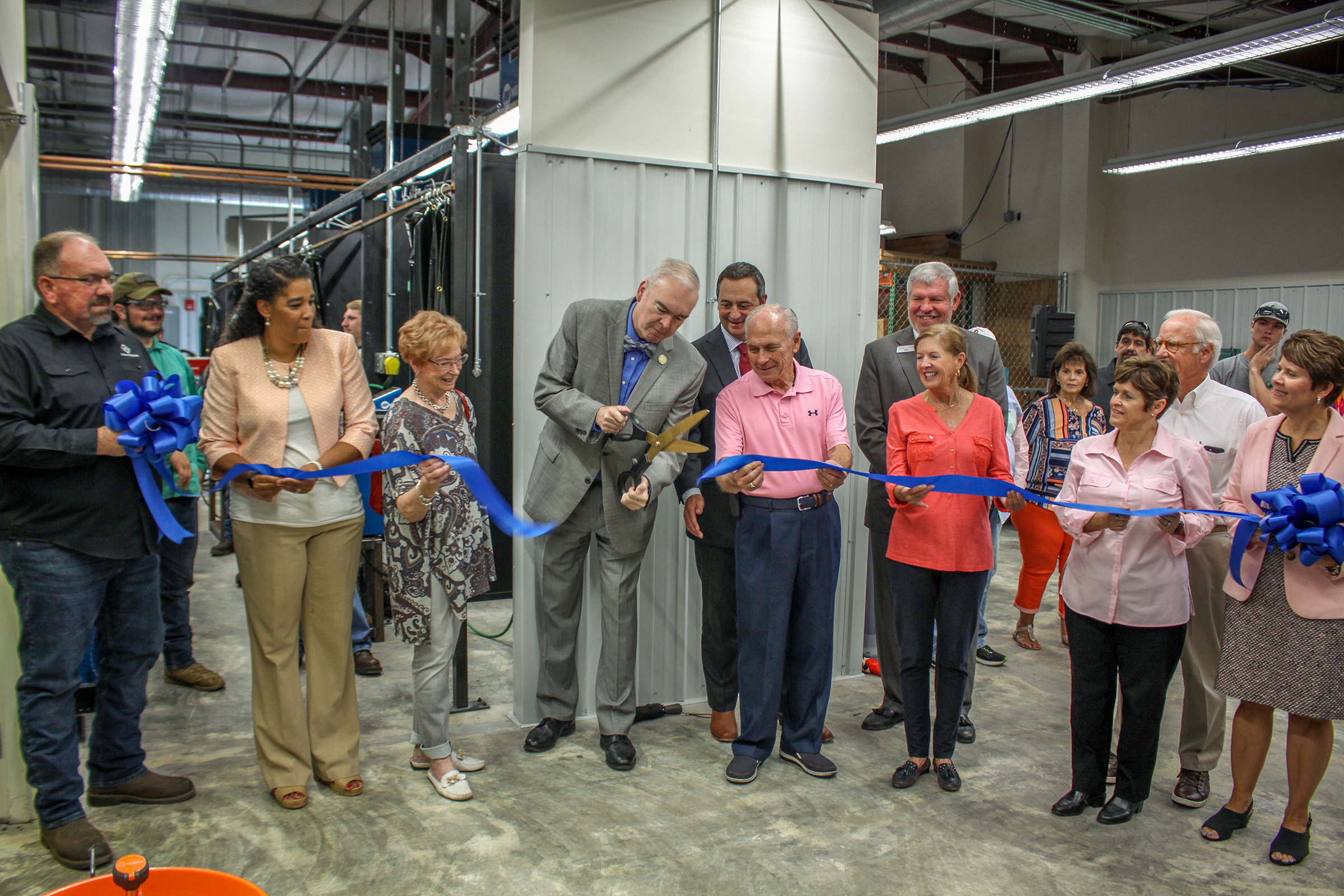 Randolph Community College President Dr. Robert S. Shackleford Jr. cuts the ribbon Thursday, opening up the newly-expanded Archdale Welding Center that increased the site’s booths to 31. Pictured from left to right are Welding Department Head Michael Ford, Director of the Archdale Center Tonya Monroe, Archdale Mayor Bert Lance Stone, Shackleford, Chairman of the Randolph County Board of Commissioners Darrell Frye, RCC Board member Dr. Cindy Schroder, Vice President of Administrative Services Daffie Garris, and Vice President of Instructional Services Suzanne Rohrbaugh. In the back row are County Commissioner Kenny Kidd, Board member James Gouty, and Board Vice Chair John Freeze.