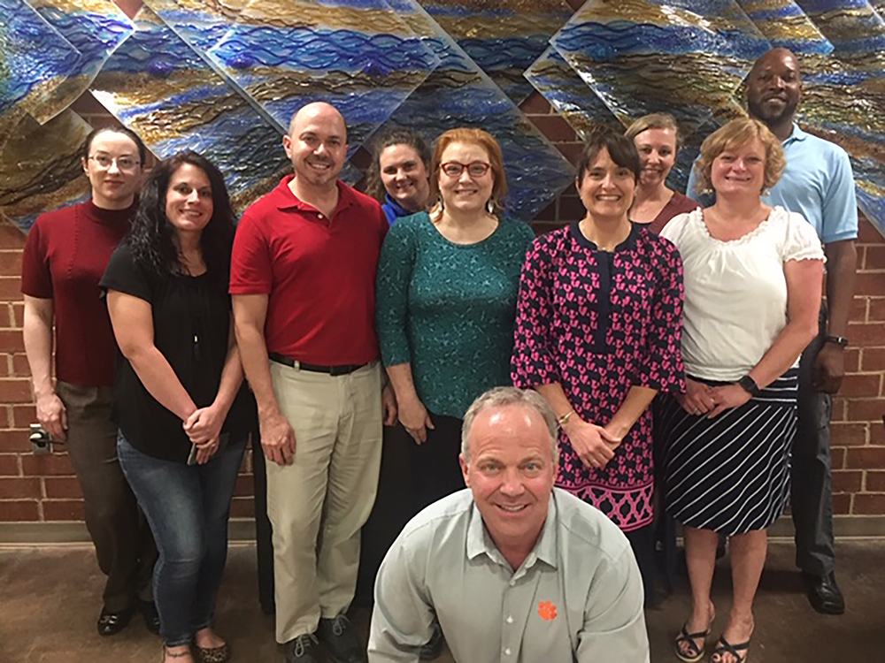 The second class of graduates from Randolph Community College's Health & Wellness Coach program celebrates finishing the course. Pictured, from left to right, are Michele Jernigan, Melissa Thompson, Shannon Foster, Kelly Hamlet, Michelle Craver, Beth Knott, Kelly Green, Dana Crisco, and Aaron Williamson. Instructor and Randolph County Wellness Administrator Sam Varner is in the front.