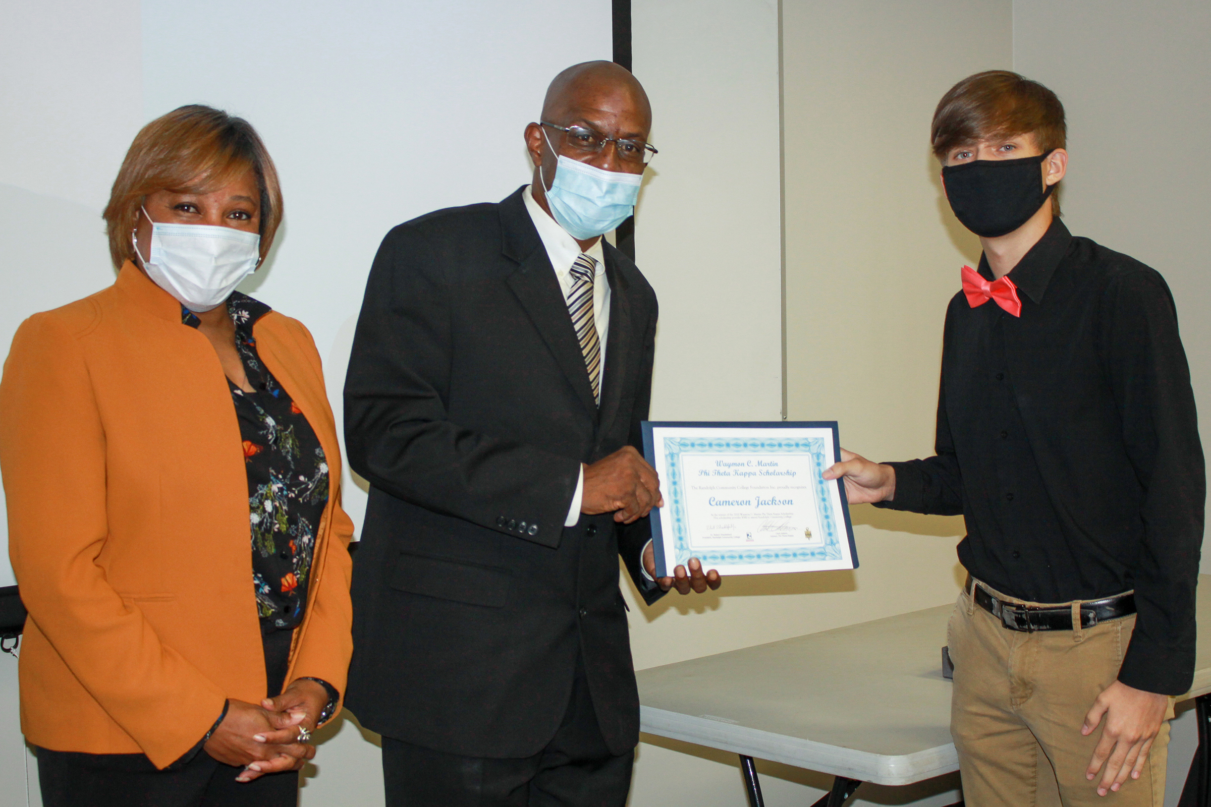 mon C. Martin’s daughter, Toi Gray, (left) and son, Hosea Martin, (center) present Randolph Community College student Cameron Jackson with the third annual Waymon C. Martin Phi Theta Kappa Scholarship on Tuesday, Sept. 25.