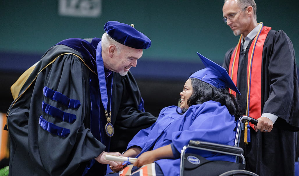 Randolph Community College President Dr. Robert S. Shackleford Jr. greets graduate Miracle Goldston, aided by Director of Safety and Emergency Preparedness Matthew Needham, during the College's 2022 Curriculum Graduation on Wednesday, May 11, at the Special Events Center of the Greensboro Coliseum Complex.