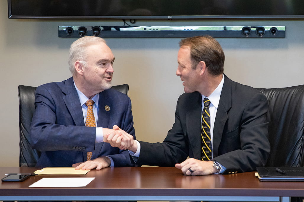 Randolph Community College President Dr. Robert S. Shackleford Jr. (right) and Pfeiffer University President Dr. Scott Bullard shake hands after signing the bilateral articulation agreement between their two schools Tuesday, April 19, in the Martha Luck Comer Conference Center on the RCC Asheboro Campus.