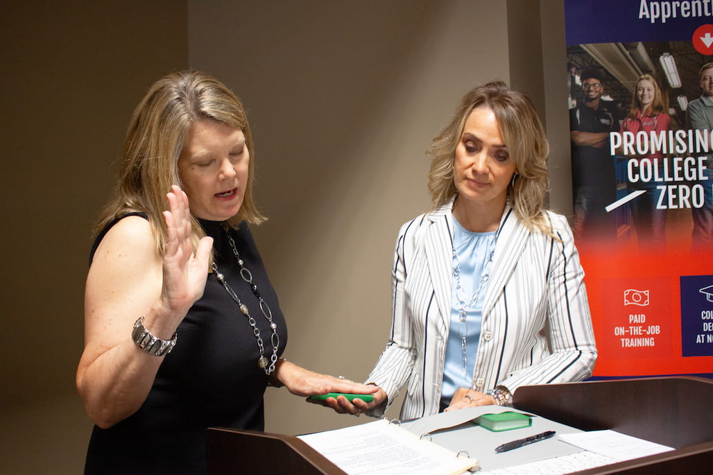 Photo of a woman taking an oath in front of another woman.