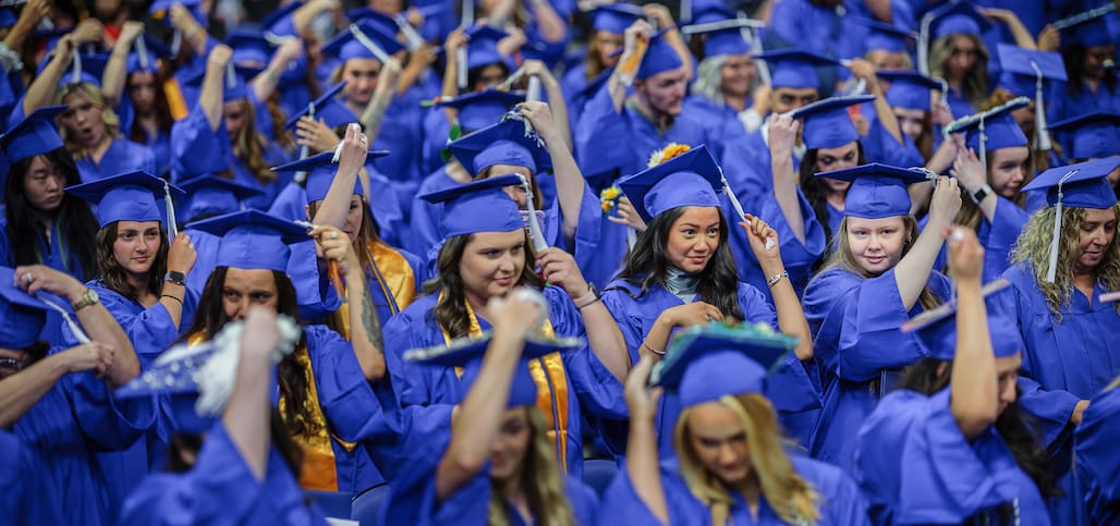 Photo of a crowd of Randolph Community College graduates turning their tassels.