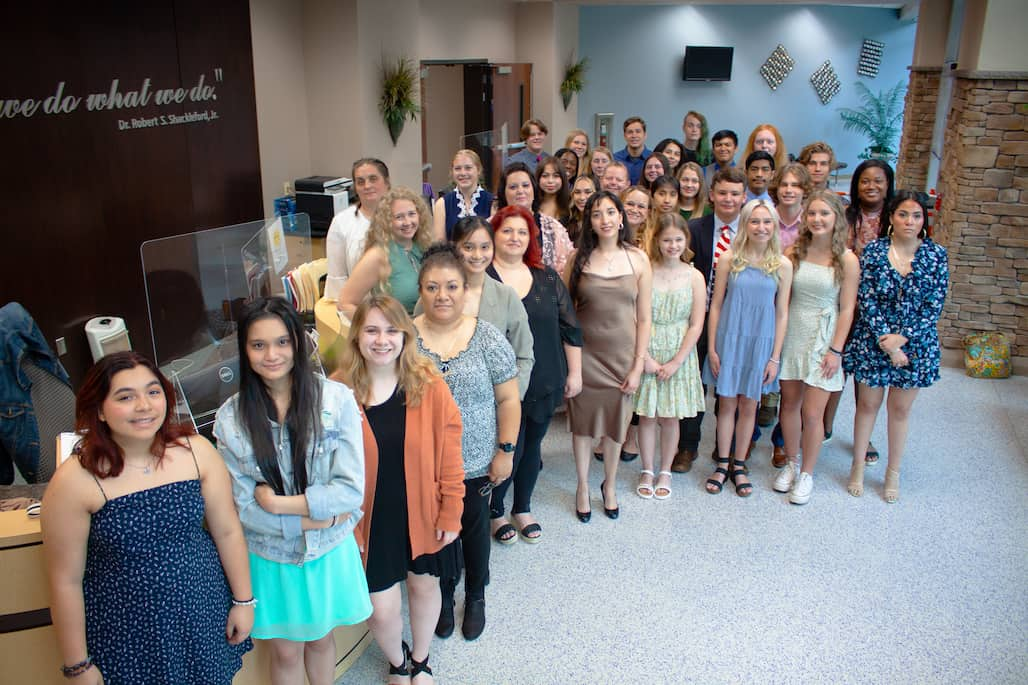 Photo of a group of students standing in an atrium.