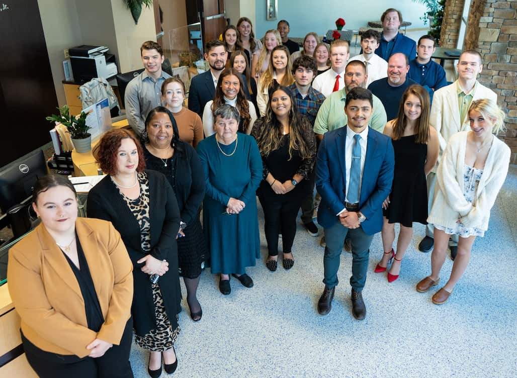 Photo of a group of people standing in a lobby.