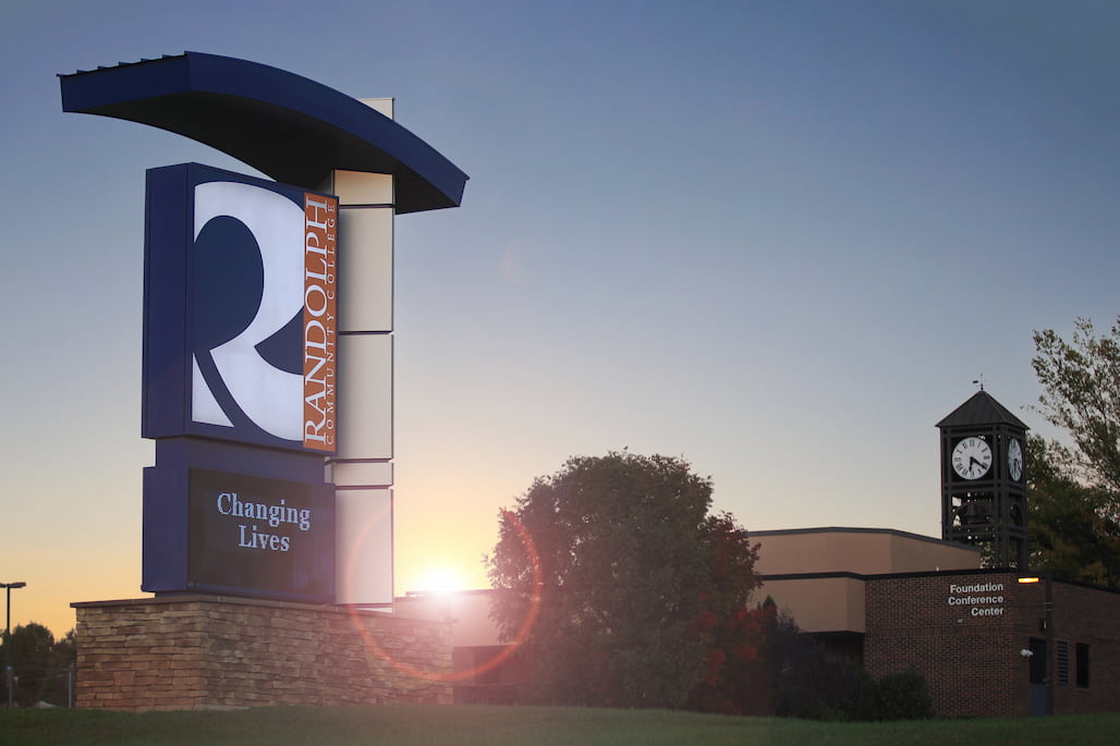 Photo of the Randolph Community College sign with a sunrise behind it.