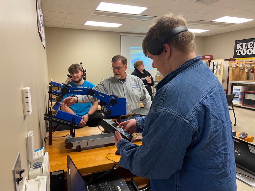 Electrical Systems Technology Instructor Tom Jones, center, leads students in an activity. The students were visiting as part of Manufacturing Day on Friday, Feb. 3.