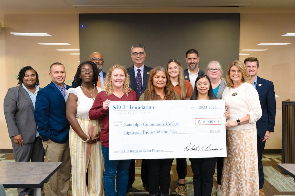 Photo of a group of people holding a large check.