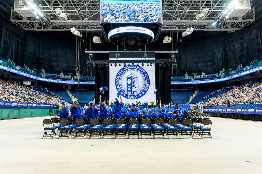 Photo of a group of graduates tossing their caps in the air.