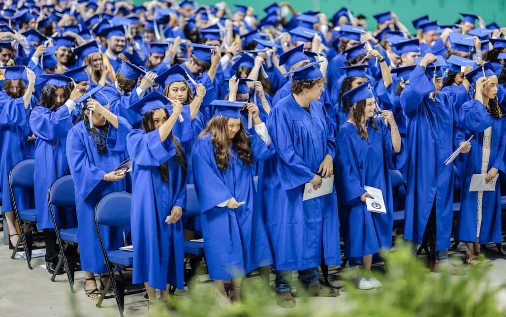 A group of graduates turning their tassels.