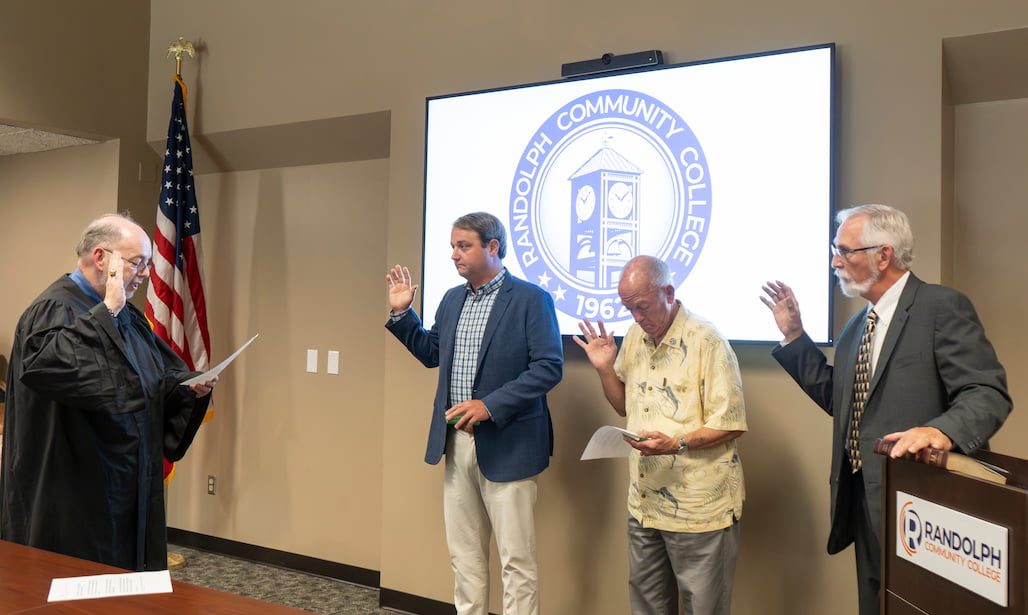 Photo of a person administering the Oath of Office to three people in RCC's Martha Luck Comer Foundation Conference Center.