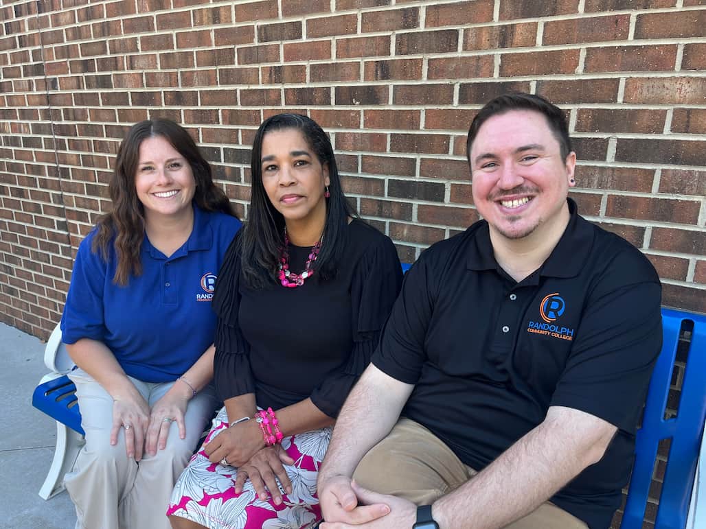 Photo of three Randolph Community College employees sitting on a bench.