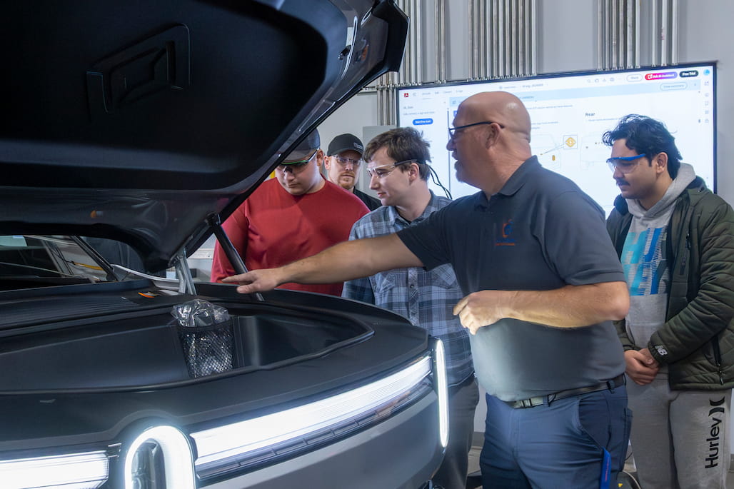 A group of people looks at a Rivian.