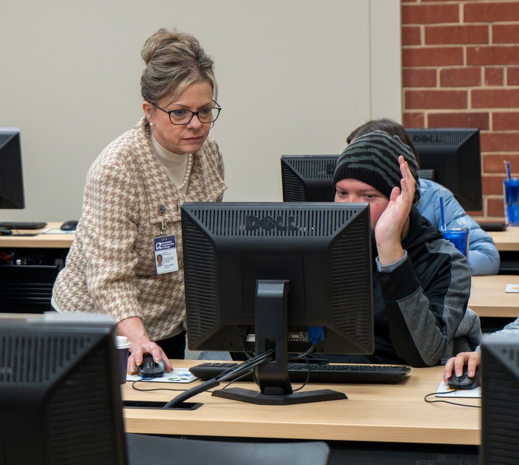Photo of an RCC employee helping out a student fill out a FAFSA.