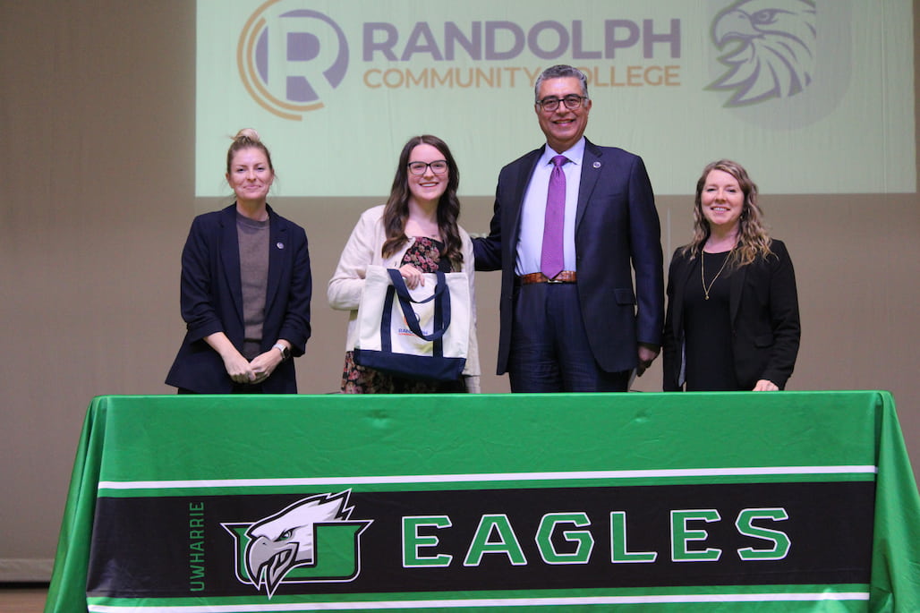 Photo of a group of people standing behind a table.