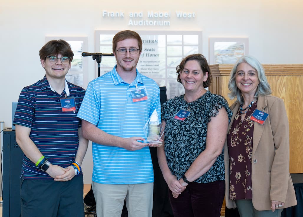 Photo of a group of people holding an award.