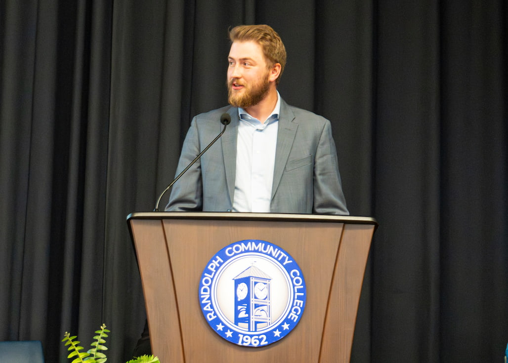 Photo of a person speaking at a podium that has the Randolph Community College seal on it.